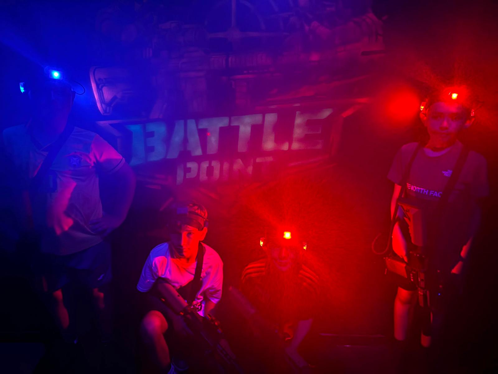Gracze w arenie laser tag Battle Point – niebieskie i czerwone oświetlenie na uczestnikach i na ścianach